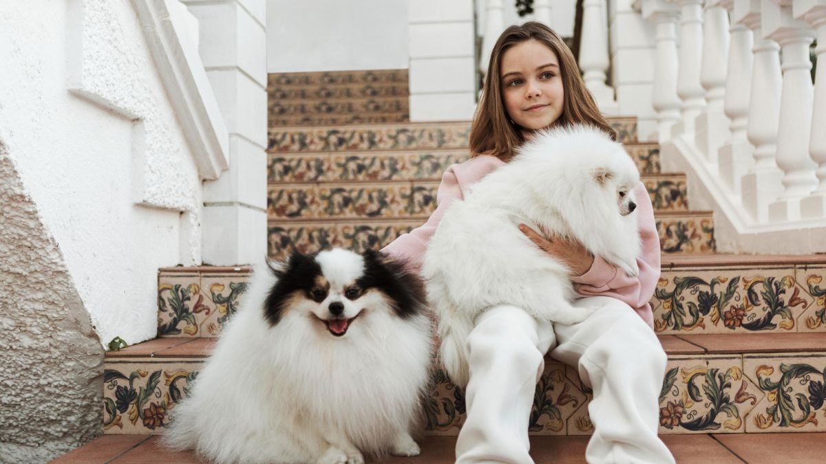 Girl holding a fluffy white dog